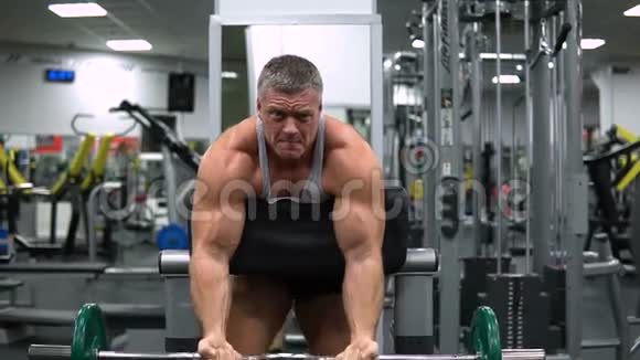 男子训练二头肌和杠铃在健身房视频的预览图