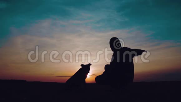 日落时一个孩子和一只狗的肖像视频的预览图