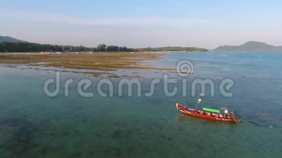 传统的泰国长尾船在低潮时在蓝海航行高清空中镜头泰国普吉岛视频的预览图