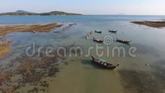 航空传统的泰国长尾船在拉瓦海滩低潮水中高清鸟瞰泰国普吉岛视频的预览图