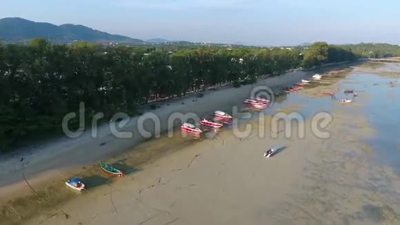 快艇站在沙滩上低潮水高清鸟瞰泰国普吉岛的拉瓦海滩视频的预览图