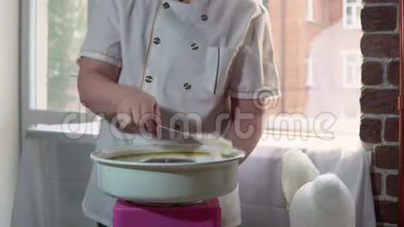年轻的男厨师在一台特殊的机器上做棉花糖视频的预览图