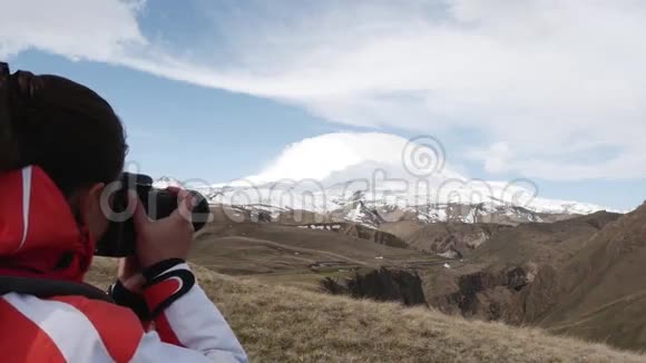 女人拍摄一座雪山视频的预览图