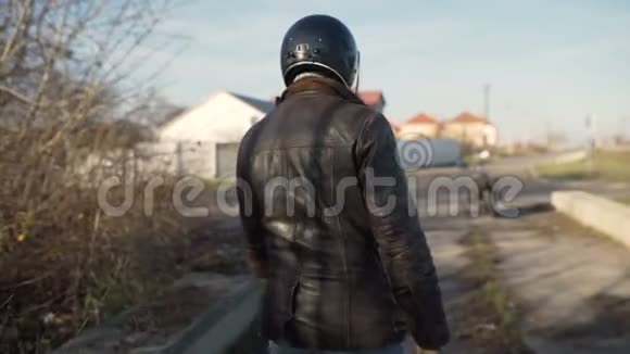 一个年轻人骑着摩托车坐在摩托车上戴上头盔去旅行视频的预览图