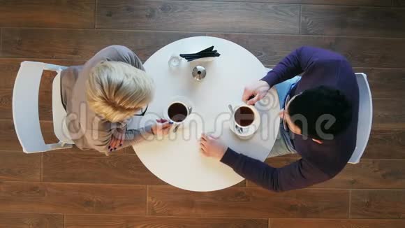 快乐的年轻夫妇在咖啡店喝咖啡聊天视频的预览图