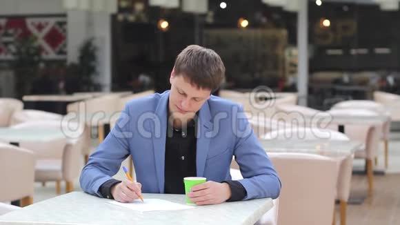 年轻的企业家在咖啡馆里写一份商业计划书视频的预览图