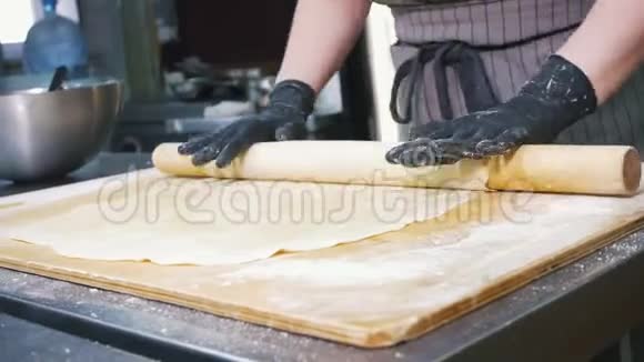 女面包师在商业厨房为苹果派准备面团视频的预览图