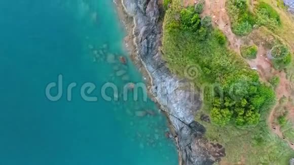 有棕榈树蓝色的水和岩石的普龙普角悬崖高清空中鸟眼镜头泰国普吉岛视频的预览图