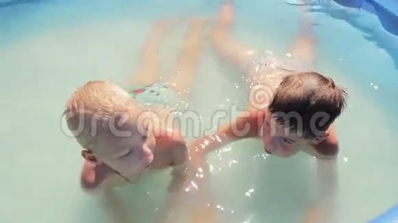 两个男孩在游泳池里特写了1080便士的喷头视频的预览图