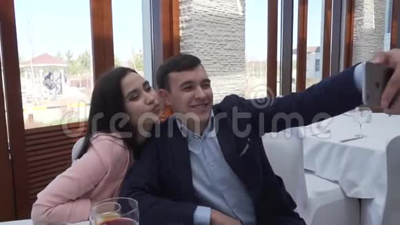 一对情侣在餐馆里用手机拍自拍股票视频视频的预览图