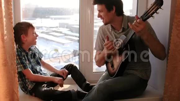 演奏乐器爸爸在弹吉他儿子在坐在窗台上打鼓视频的预览图