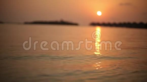 在马尔代夫日出或日落时欣赏热带泻湖和豪华的水上平房视频的预览图