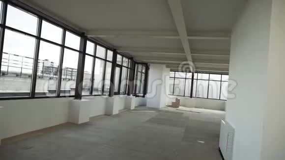 大的空公寓有黑色的框架窗户和白色的墙壁和天花板视频的预览图