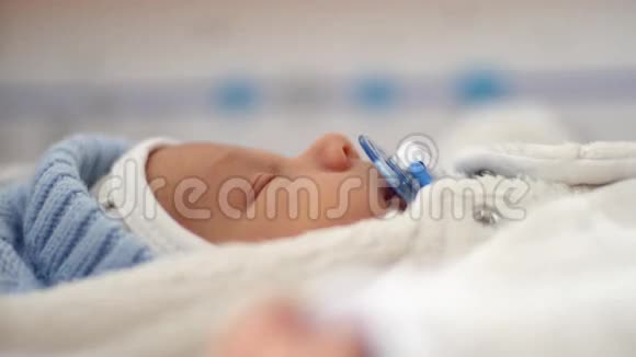 一个新生婴儿躺在发光的灯光下视频的预览图