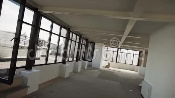 大的空厅有大的黑色框架窗户和白色墙壁和天花板视频的预览图