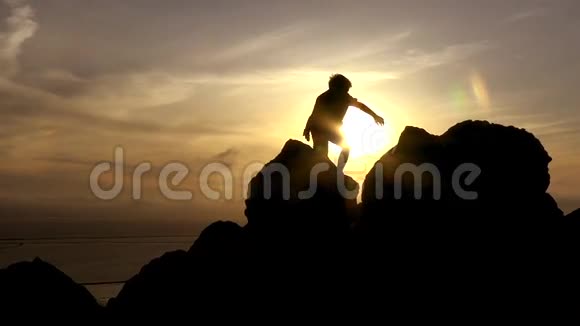 男孩在日落时攀岩视频的预览图