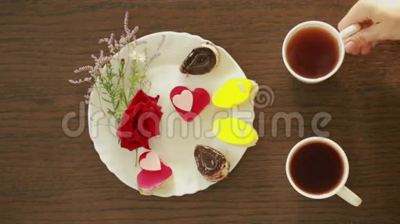 杯子里的红茶和咖啡有饮料和甜点的桌子情人节视频的预览图