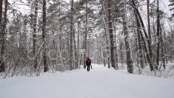 夫妇在冬天的森林里跑步慢动作视频的预览图