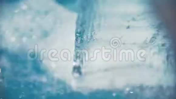 从金属瀑布流入蓝色游泳池的水流曲线视频的预览图