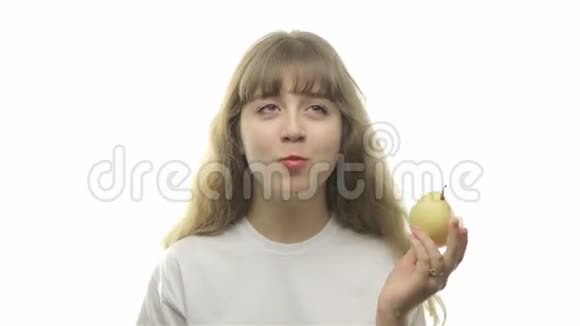 年轻的金发女孩在吃梨视频的预览图