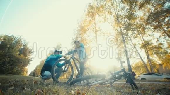 在秋天的森林里骑自行车旅行的坑站修理自行车视频的预览图