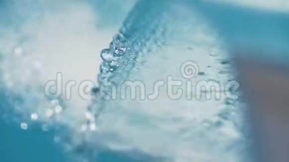 从金属瀑布缓缓流入蓝色游泳池视频的预览图