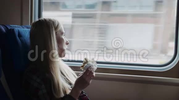 美丽的女人在火车旅行时吃三明治视频的预览图