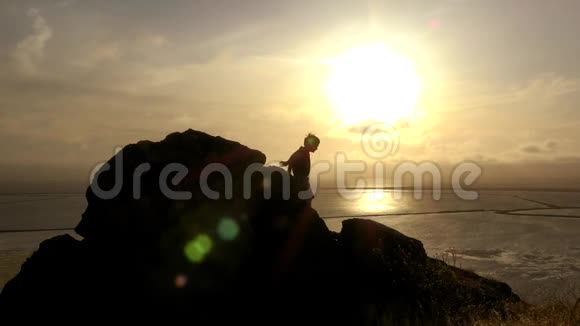 男孩在日落时攀岩视频的预览图