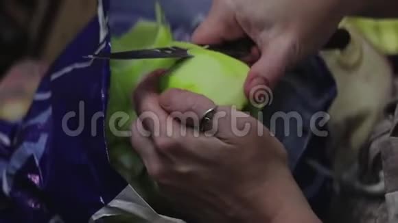 用刀子清洗苹果的女孩的手特写在上面视频的预览图