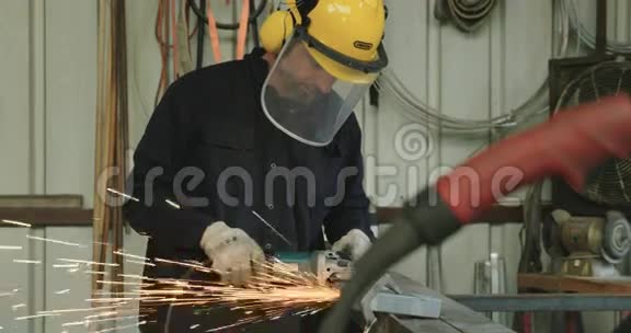 一名工人用金属磨床磨削金属的慢速镜头视频的预览图