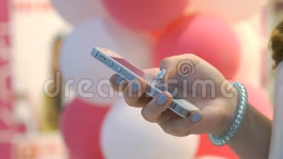 气球背景上拿着智能手机的女孩视频的预览图