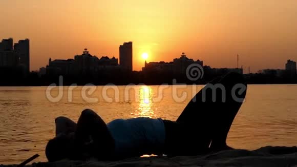 女孩在日落时在海滩上练习轮泳视频的预览图
