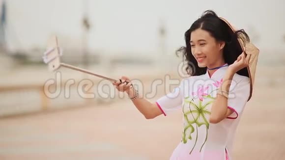 穿着越南民族传统服装的女孩自己用手机拍照视频的预览图