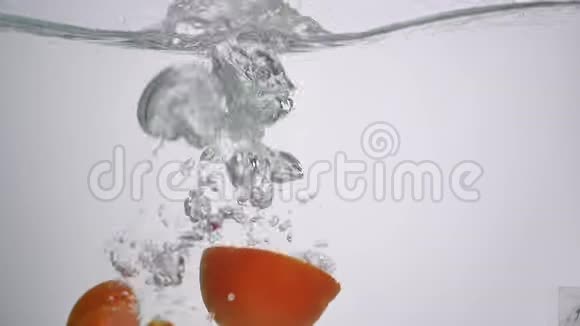 在白色背景下切割成水的西红柿视频的预览图