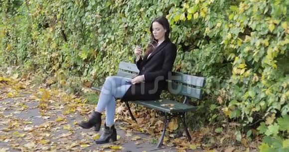 在公园长椅上听音乐的女人视频的预览图