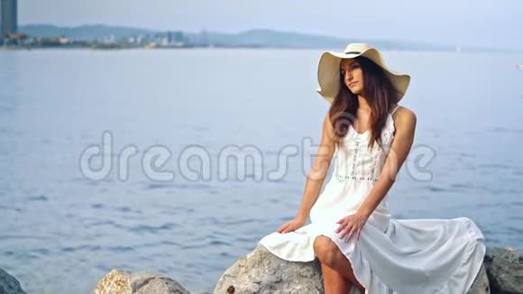 穿着白色裙子戴着帕梅拉帽子的漂亮女人视频的预览图