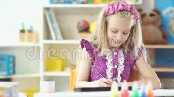 漂亮的小女孩穿着薰衣草的连衣裙画画女孩微笑着视频的预览图