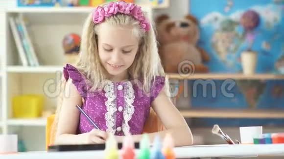 漂亮的女孩用彩色铅笔仔细画画视频的预览图