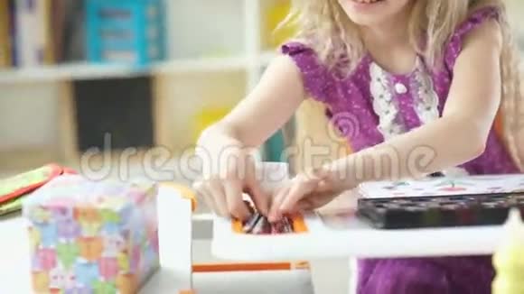 女孩画画漂亮的金发女孩从盒子里拿出蜡笔视频的预览图