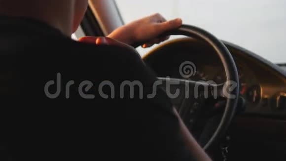 开车的年轻人严肃的家伙开车沿着乡间小路从车里看后方视野稳定射击视频的预览图