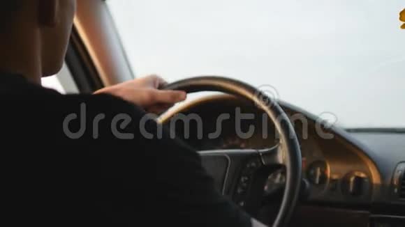 开车的年轻人严肃的家伙开车沿着乡间小路从车里看后方视野稳定射击视频的预览图