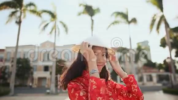 越南女孩在岘港市傍晚夕阳的余晖中戴上一顶国家帽子视频的预览图