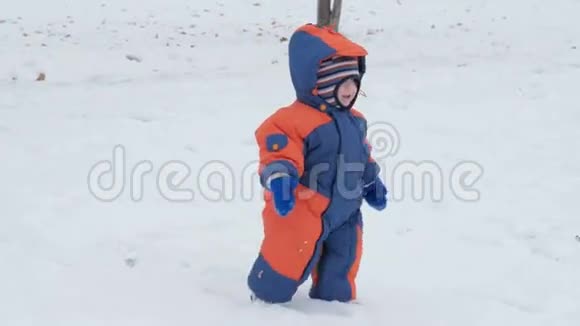 小美丽的宝宝掉进雪里妈妈帮助儿子起床一个穿着工作服的男孩大约一年了视频的预览图