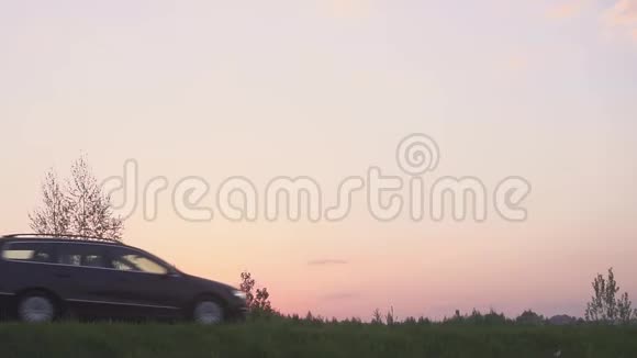 日落时一辆汽车在田野里的剪影路和田野场上的车视频的预览图