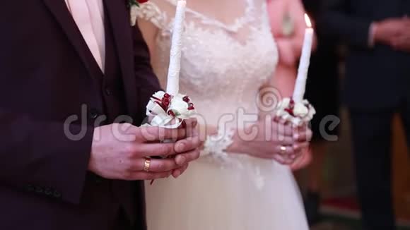 教堂新娘和新郎在婚礼上拿着蜡烛视频的预览图