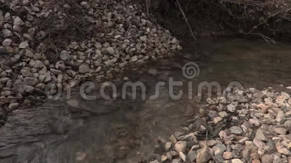 带着登山杖穿过小溪的人视频的预览图