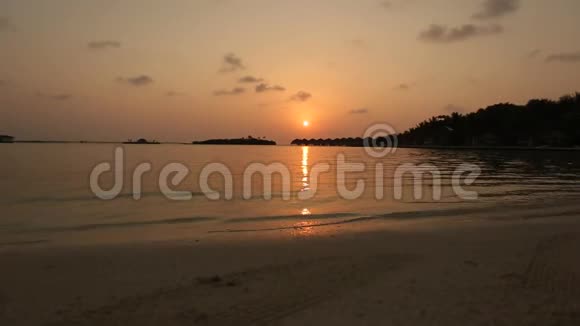 在马尔代夫日出或日落时欣赏热带泻湖和豪华的水上平房视频的预览图