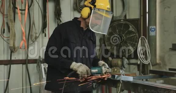 一名工人用金属磨床磨削金属的慢速镜头视频的预览图
