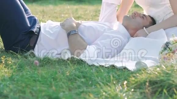 新娘和新郎在草地上休息视频的预览图