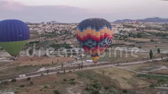 许多五颜六色的热气球飞在山上卡帕多西亚日出时的全景视频的预览图